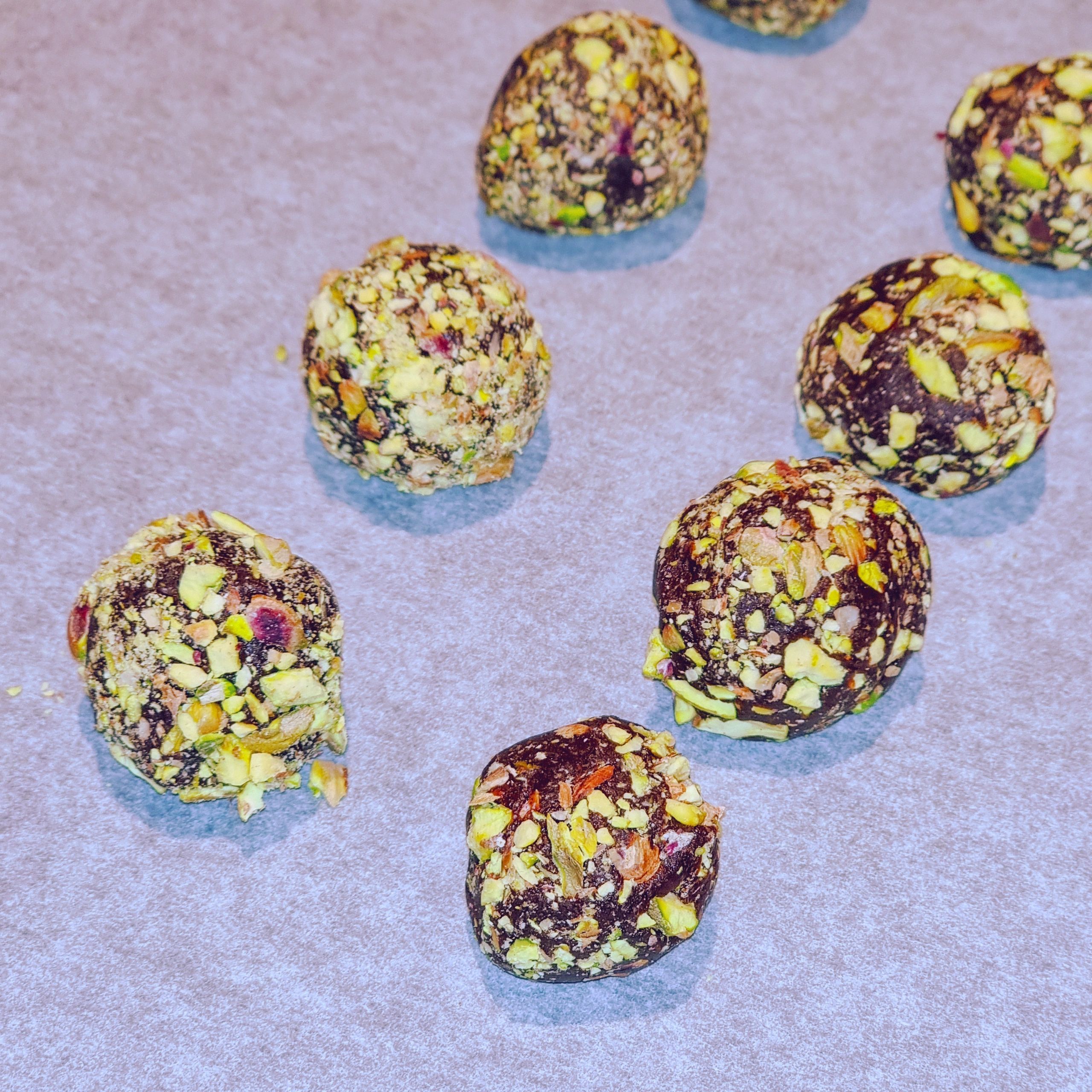 Trufas de chocolate con pistacho sobre papel encerado