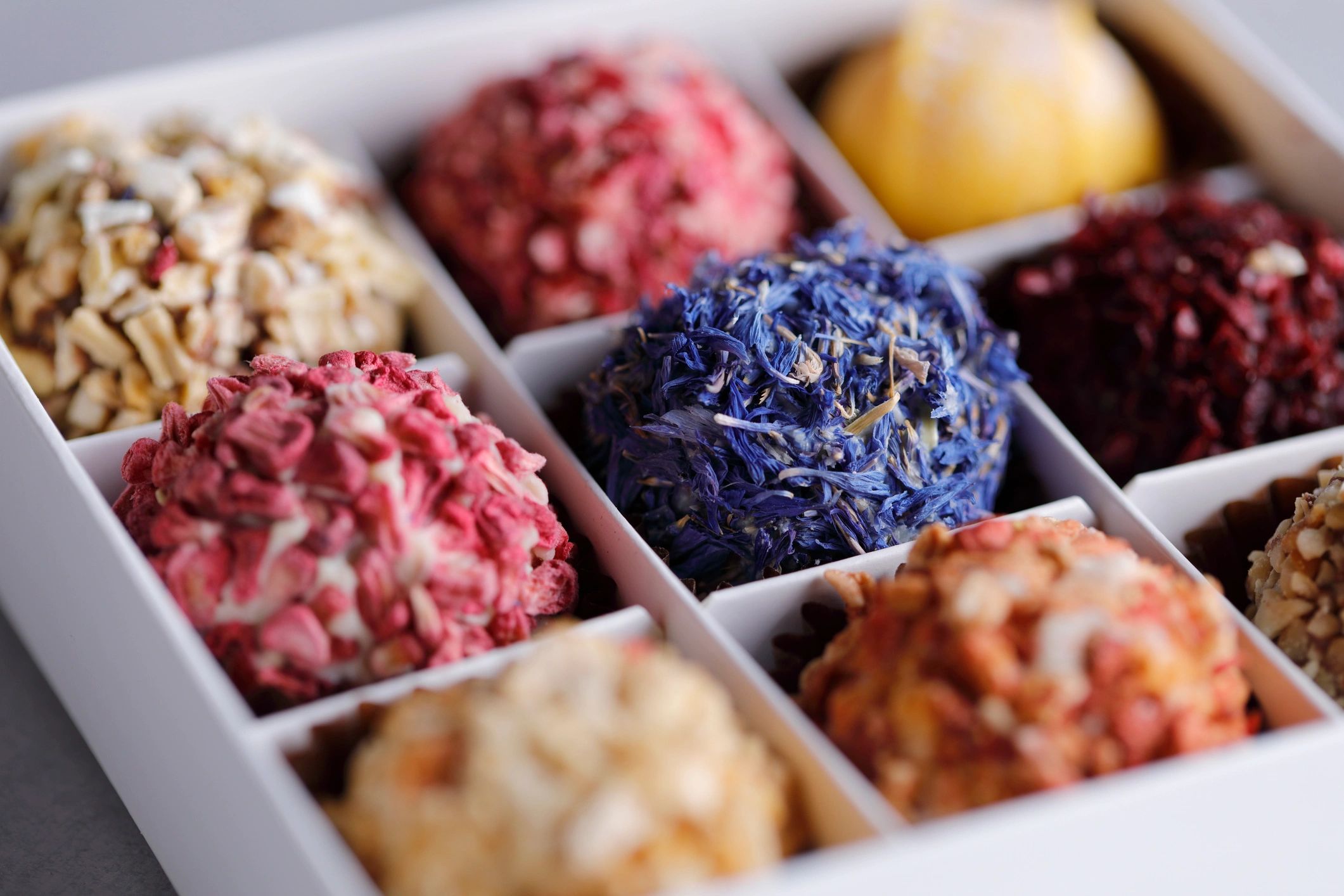 Trufas de chocolate decoradas con pétalos comestibles en caja